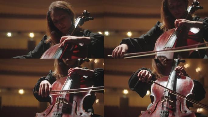 漂亮的音乐家女人在音乐厅演奏大提琴，歌剧院现场的女小提琴演奏家