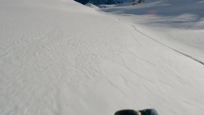 在阳光明媚的日子里，滑雪者从白雪皑皑的山腰下降的第一人称视角