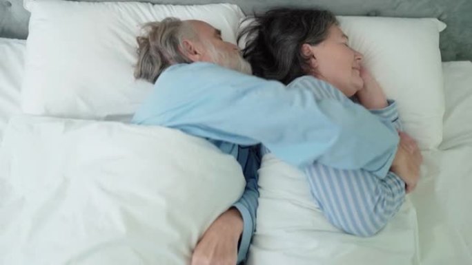 老年养老金领取者拥抱妻子，一起睡在床上，温柔的关系