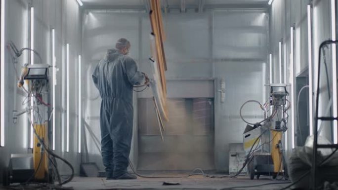 总体计划一个戴着呼吸器的人正在用粉末方法涂金属。钢铁和金属结构的生产。画店。画家用喷枪涂漆作品
