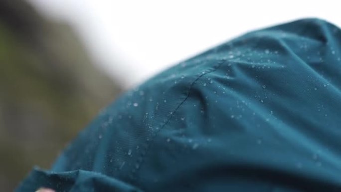 蓝色绿松石雨夹克兜帽上的雨特写镜头