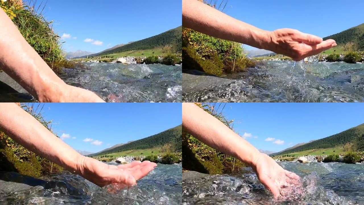 女人的手从清澈的溪流中捞水的细节