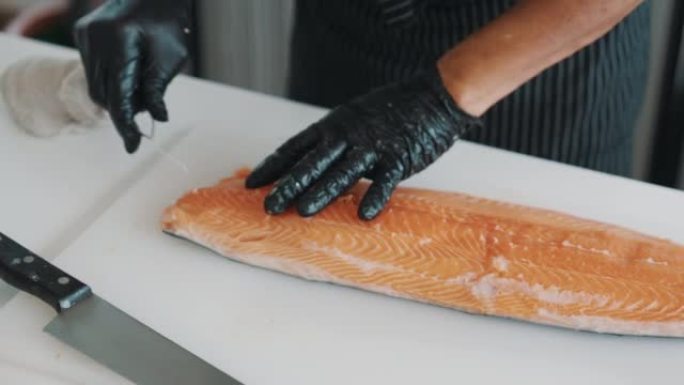 日本厨师正在从鲑鱼中去除鱼刺。