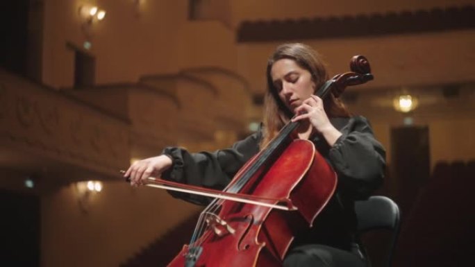 emotional woman is playing violoncello in music ha