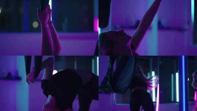 一个女人在霓虹灯的工作室里跳舞，表演着慢动作的伸展和跳舞的优美练习和动作