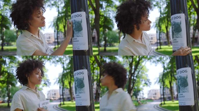 沮丧的黑人妇女寻找她想念的狗，用宠物照片悬挂海报