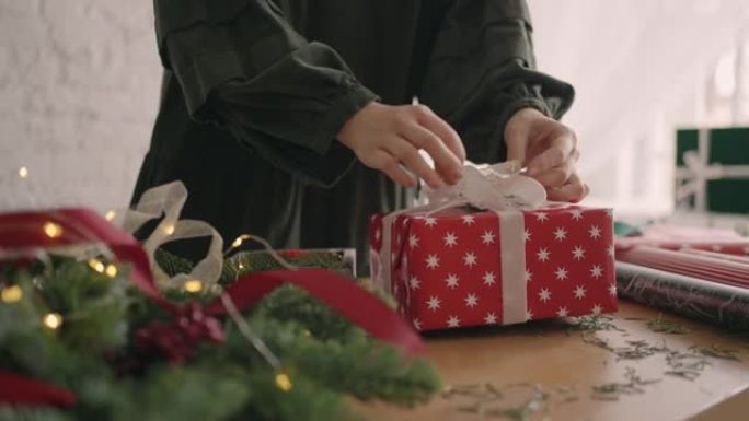 包装圣诞礼物。女人用环保圣诞装饰包装礼物，为节日做准备。
