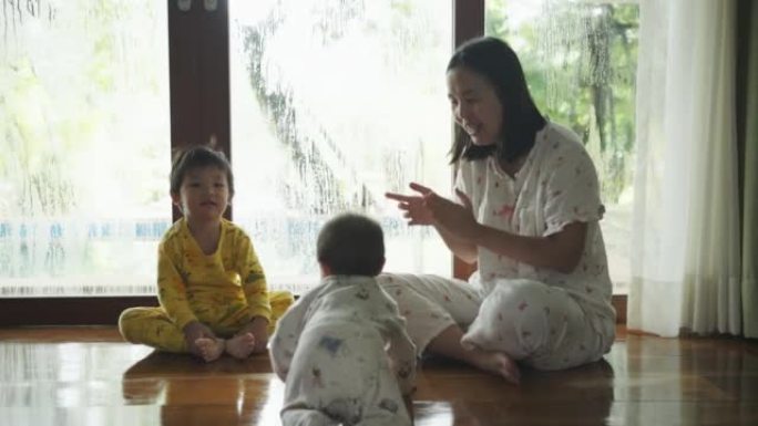 快乐的亚洲蹒跚学步的男孩在早上醒来后与小弟弟一起玩耍