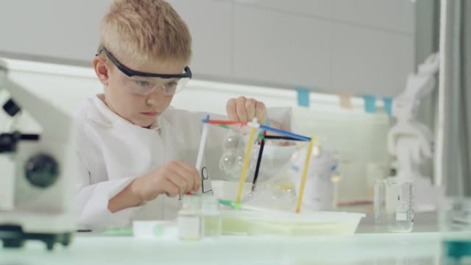 男孩在实验室进行科学实验。用肥皂泡液体研究表面张力