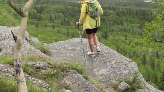 女性徒步旅行者到达山麓上方的悬崖边缘