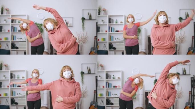 戴着医用口罩的老年和年轻妇女在家锻炼，在大流行中运动