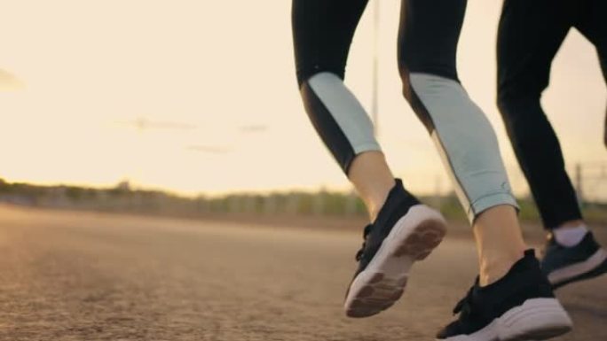 户外运动训练，三名跑步者一起跑步，运动鞋中的脚特写视图