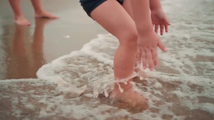 母亲牵着小儿子在芭堤雅海滩上一起玩。