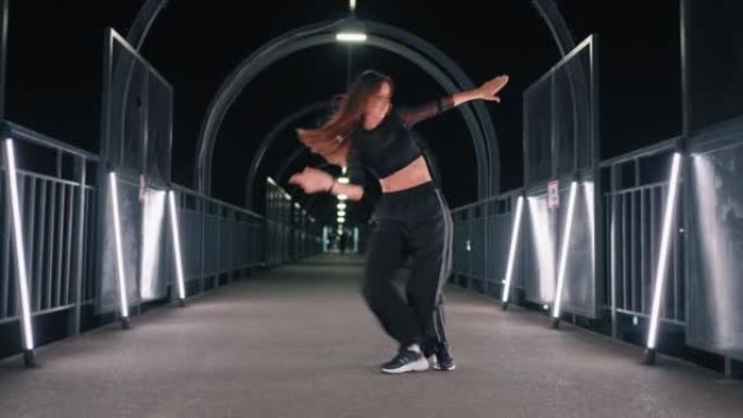 富有表现力的女舞者在人行天桥的黑暗隧道中跳舞嘻哈舞蹈
