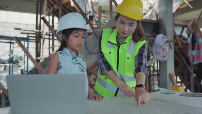 小工程师和母亲对平板电脑感兴趣的建筑工地。
