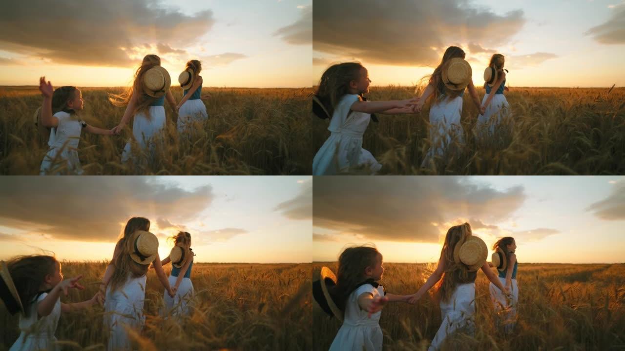 欢快的儿童姐妹在收获季节牵着手在美丽的麦田上奔跑