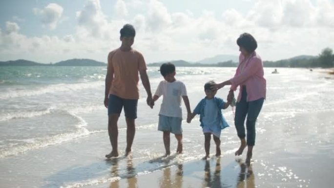 亚洲家庭带着幸福的情感在沙滩上散步