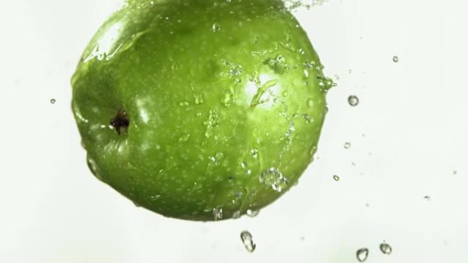 绿色苹果在白色厨房背景下的慢动作飞行