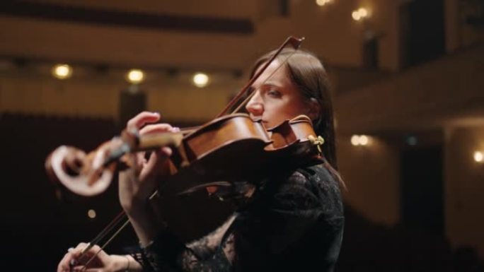 女小提琴手在音乐厅独奏，歌剧院现场有才华的女音乐家的肖像