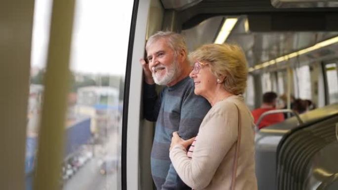 沉思的高级夫妇在地铁列车上看着窗户