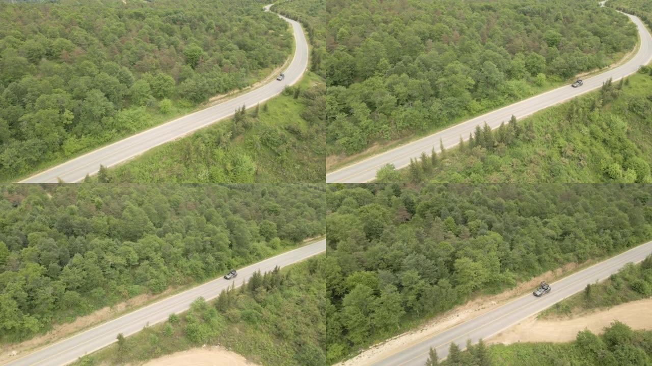 在森林道路上方飞行的鸟瞰图，单车行驶