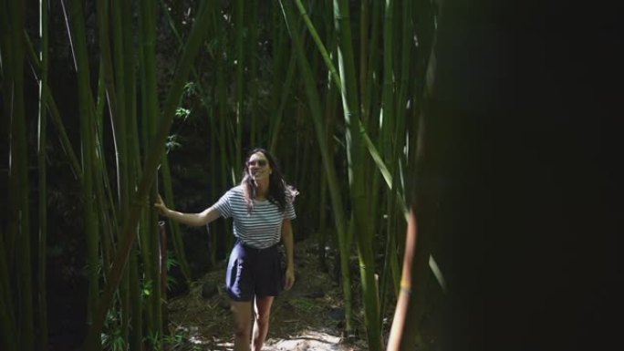 年轻女子走过竹林旅游观赏风景好奇心