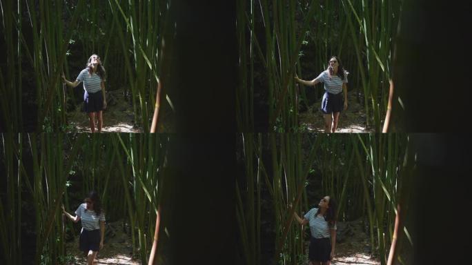 年轻女子走过竹林旅游观赏风景好奇心