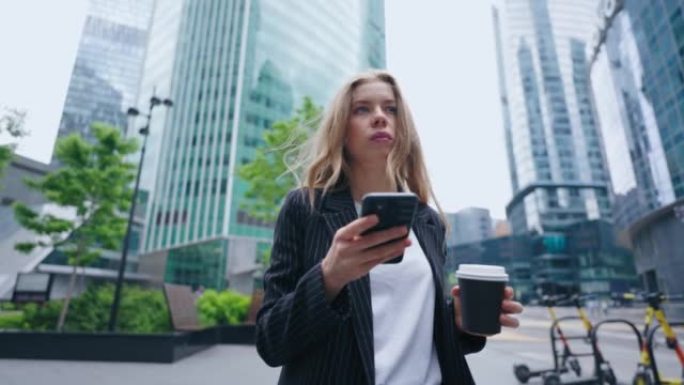 市中心街头沉迷于网络的女人，用手机描绘自信的女商人