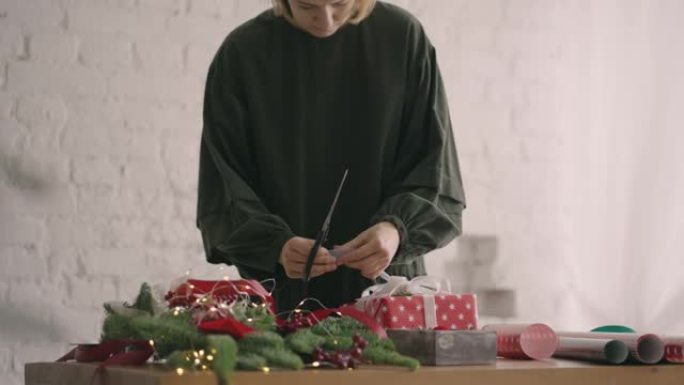 用绳子装饰包裹的盒子。女性包装纸板礼品盒为圣诞节庆祝准备的各种装饰物品。细节女性双手系绳