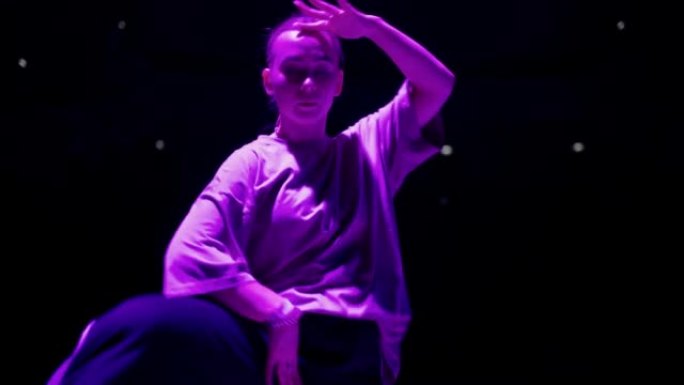 十几岁的女孩在紫光的舞蹈战斗中跳舞嘻哈，街舞和青少年的亚文化