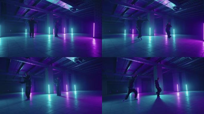两位霓虹灯中的嘻哈舞者以蓝色和紫色一起跳舞。