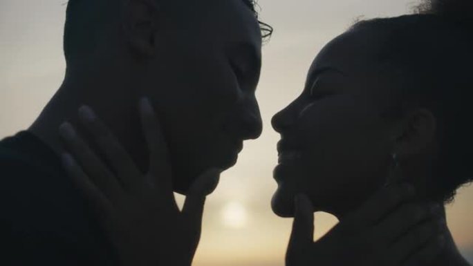 日落浪漫约会的特写非洲族裔夫妇。爱的拥抱