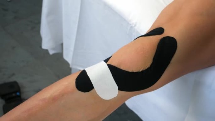 受伤后固定膝关节的女性腿部运动学磁带，特写视图。