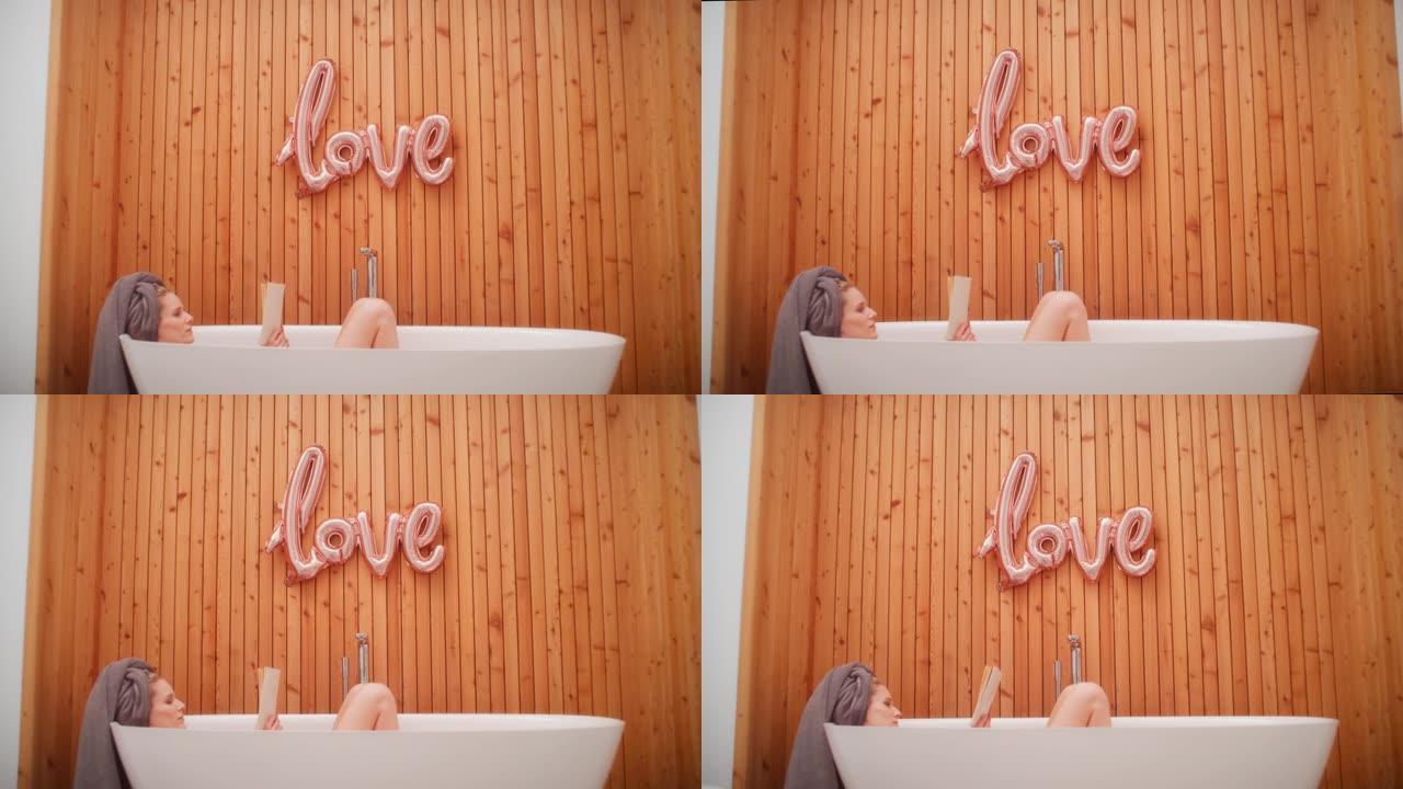 女人在现代简约浴室放松，带有 “爱” 字体。在浴缸里读书，自爱隐喻