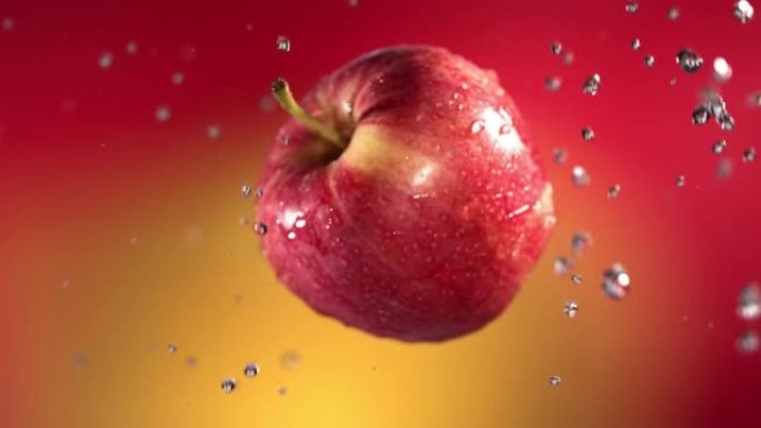 红色黄色背景下的红苹果在慢动作中的飞行