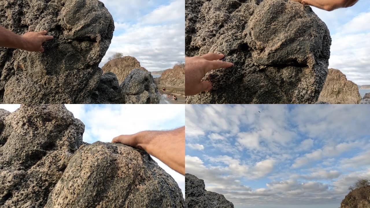人类双手攀爬海岸岩石的特写镜头