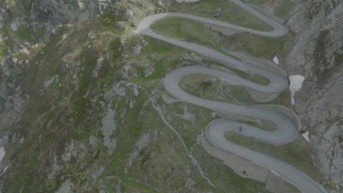在瑞士阿尔卑斯山阳光明媚的日子里，旧的Tremola Gotthard路的空中无人机视图