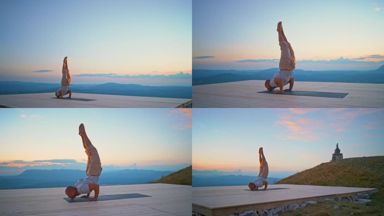 CS男子在黄昏时将双腿抬到山上的空中做瑜伽姿势