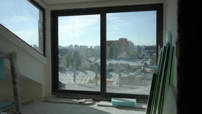 阳光明媚的日子，基辅乌克兰在新大楼的大窗户上。以城市为背景的在建房地产。