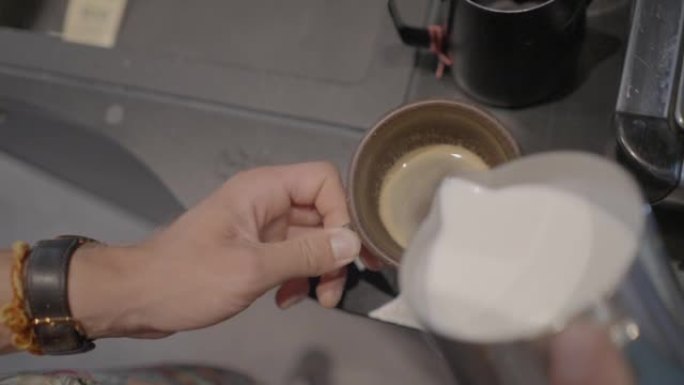 咖啡师在咖啡中倒牛奶的特写镜头