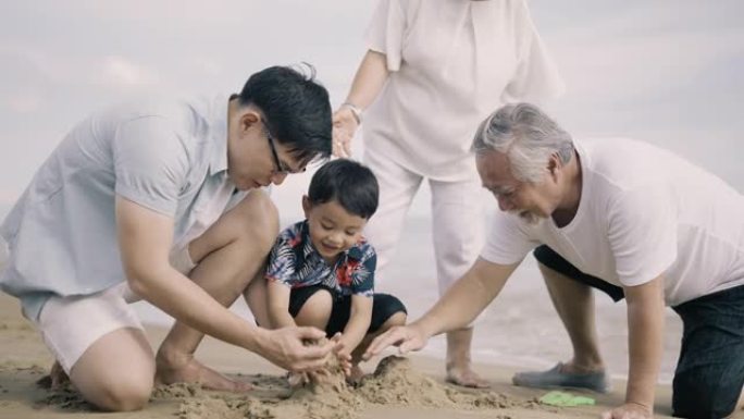 亚洲家庭在沙滩上玩沙子