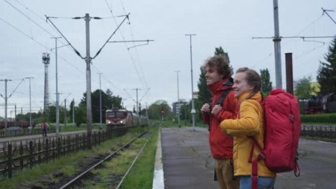 年轻夫妇走在火车轨道上，等待火车