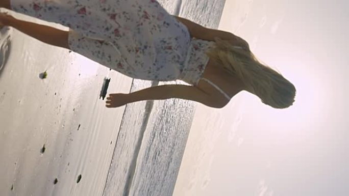 海滩漫步。穿着夏装的女人在热带海岸线上享受日落。反转视频