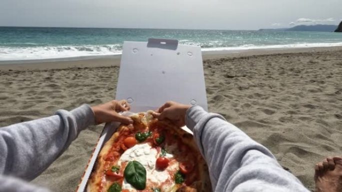 年轻女子喜欢在海滩上吃披萨