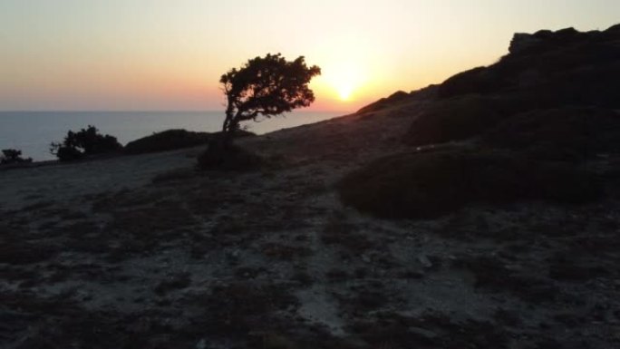 日落时地中海沿岸山坡和海洋的鸟瞰图