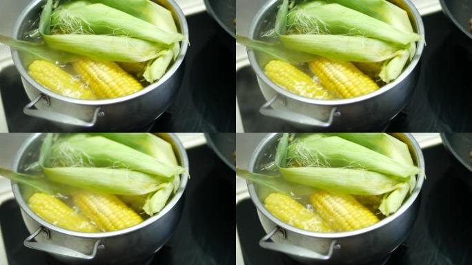 甜黄色美味的煮玉米在平底锅里煮沸。在热沸水中关闭煮沸的玉米棒。黄玉米的成熟穗在沸水中添加维生素以保持