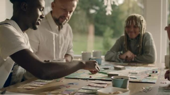 多元化的家庭，非裔美国人的孩子一起在桌子上玩棋盘游戏