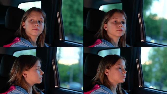 特写着严肃表情的小漂亮女孩在车里旅行，透过窗户看。悲伤的高加索女性儿童在乘车时。汽车旅行的概念