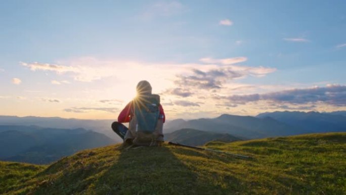 DS女徒步旅行者坐在山顶看日落