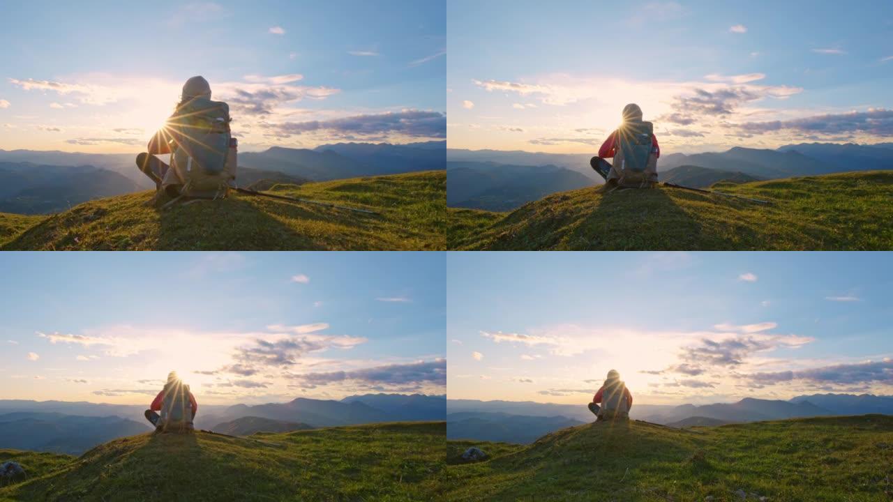 DS女徒步旅行者坐在山顶看日落